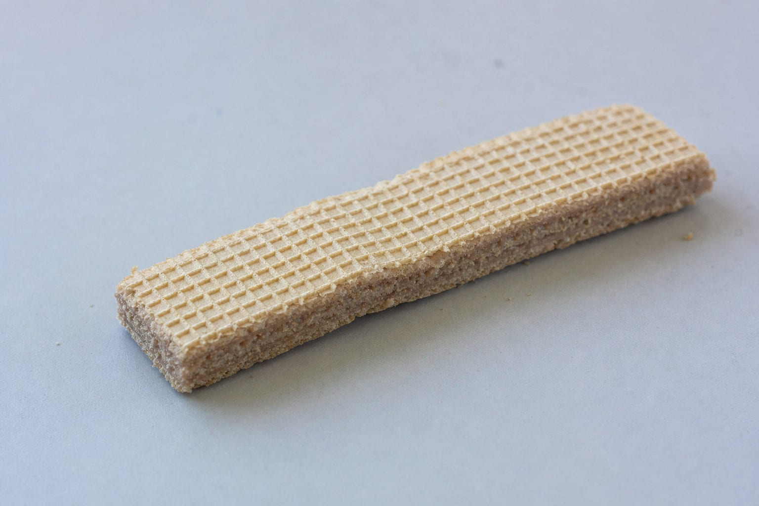 um-biscoito-wafer-com-aspecto-murcho-e-amolecido-deitado-sobre-uma-superficie-li