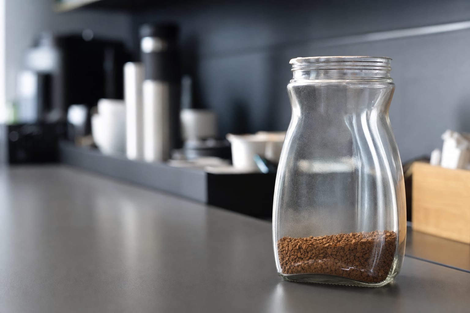 um-close-up-de-um-pote-de-cafe-soluvel-quase-vazio-no-balcao-de-uma-copa-corpora